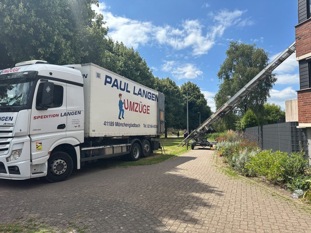 Umzugswagen von Paul Langen steht vor Wohnhaus mit ausgefahrenem Möbellift für Privatumzug